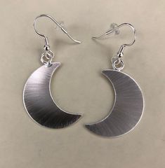 I've designed a pair of crescent moon earrings, 1 1/8 inches each in size, with dangling ear hook wires. The set is completely handmade in sterling silver. Inspired by Stevie Nicks, I wanted to fabricate matching earrings to the moon pendant and as this was for a customer request, I thought, what a grand idea! I can offer a 24K gold plating option that I will include in the drop down menu at checkout! The last image is to show the crescent moon necklace. Please convo for any questions! Allow me Celestial Half Moon Phase Earrings, Celestial Half Moon Earrings With Moon Phase Detail, Celestial Crescent Moon Phase Earrings, Crescent Shaped Earrings With Ear Wire For Gifts, Half Moon Ear Wire Jewelry For Gift, Half Moon Ear Wire Jewelry Gift, Sterling Silver Crescent Earrings With Ear Wire, Crescent Moon Charm Earrings As Gift, Adjustable Moon-shaped Minimalist Earrings