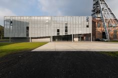 the building has many windows and is next to a large metal structure with a ladder on it