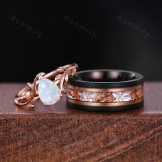 two wedding bands with white opal inlays and rose gold leaves on them