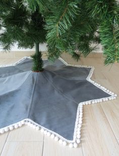 a christmas tree skirt with pom - poms on the bottom