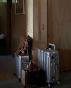 two pieces of luggage sitting on the floor next to each other in front of a door