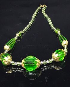 Very pretty vintage green faceted crystal necklace  with a spring ring clasp : signed on clasp . ( Czech) Total length approximately 45Cm  Extremely large moulded/ faceted crystals largest measures approximately 2 Cm x 1.5 Cm and long green beads are 3 cm long. A chunky and unusual vintage necklace set with large gold tone metal accent bead caps and small glass beads . On the original string , good clean condition. Signed Czech necklaces are becoming scarce. Gift wrapped and ready to wear Green Glass Round Bead Jewelry, Green Glass Necklace For Party, Elegant Green Glass Jewelry, Green Czech Glass Necklaces For Party, Green Glass Jewelry With Faceted Beads, Green Faceted Round Bead Necklaces, Green Faceted Round Beads Necklace, Elegant Green Glass Necklaces, Formal Green Beaded Necklace With Faceted Beads