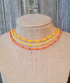 Orange Seed Bead Choker - Yellow Seed Bead Choker - Tangerine Seed Bead Choker - Orange Choker - Yellow Choker - Orange Seed Bead Necklace Perfect chokers for beachware! ORANGE:  features orange, red, and gold seed beads. YELLOW:  features yellow, gold, white, and orange seed beads. CITRIS:  features tangerine, gold, and orange seed beads. All have a silver-plated lobster clasp with 3-inch extender chain. Chokers are 15 to 18" around. Orange Beaded Necklace For Festivals, Orange Heishi Beads Necklace, Adjustable Orange Beaded Necklaces With Heart Beads, Adjustable Orange Beaded Necklace With Letter Beads, Adjustable Orange Beaded Necklace With Heart Beads, Orange Seed Bead Necklace, Orange Tiny Beads Choker Necklace, Seed Bead Orange, Festival Orange Hand-strung Beaded Necklaces