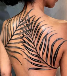 the back of a woman's neck with black leaves on her upper and lower part