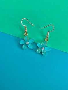 These dangle earrings are blue flowers with a clear gemstone layer on top of it, with a rhinestone in the center and a gold backing. There is also some gold detailing in the lines in the flower. These have a fish hook closure. Turquoise Crystal, Earrings Turquoise, Gold Flower, Gold Flowers, Blue And Gold, Fish Hook, Gold Details, Dallas Tx, Crystal Rhinestone