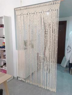 a room with a white curtain that has fringes hanging from the ceiling and on the wall