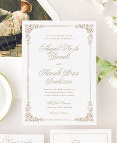 the wedding stationery is set on top of a table with flowers and an envelope