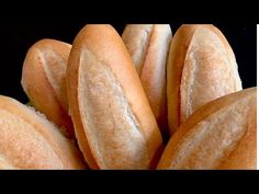 a bunch of bread rolls stacked on top of each other in front of a black background