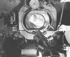 a black and white photo of a man working in a machine shop with lots of machinery