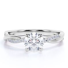 a white gold engagement ring with diamonds on the band and a round brilliant center stone