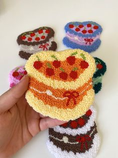 a hand is holding a piece of crocheted cake