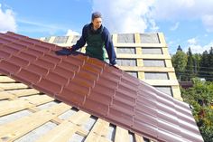 a man standing on top of a metal roof