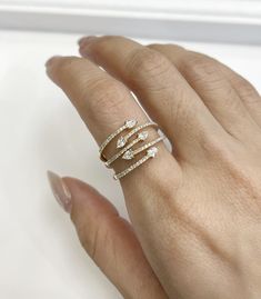 a woman's hand wearing a gold ring with three stones on it and two diamonds in the middle