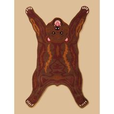 a brown bear rug with pink eyes on it's back and arms stretched out