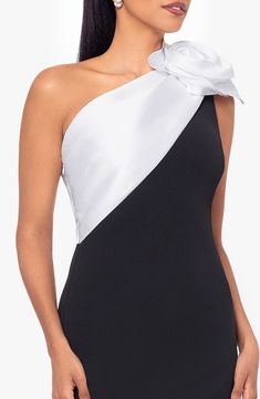 a woman wearing a black and white one shoulder dress