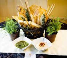 a table topped with bowls filled with different types of breads and veggies