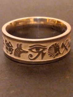 You are buying the Egyptian inspired ring pictured, it features a wonderful stainless  steel band with Egyptian symbols etched all the way around. This wonderful ancient Egyptian pattern inspired Ring will look amazing, very classic look, a great silver-tone accessory for that Egyptian look. Available in size 9  , these lovely rings are new old stock I got them from a costume jewelry warehouse that went out of business in the late 1990s. Please Note: These are comfort fit rings (rounded on the i Ancient Egyptian Accessories, Egyptian Rings, Egyptian Jewelry Ancient, Egyptian Ring, Egyptian Accessories, Egyptian Pattern, Ancient Egyptian Jewelry, Ring Mandrel, Egyptian Inspired