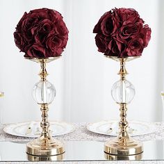 there are two vases with flowers in them on top of the table, one is gold