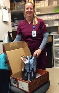 a woman in scrubs standing next to a box filled with shoes and other items