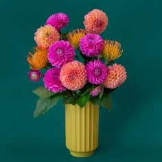 A beautiful chartreuse fluted cylindrical vase sits in middle of a page.  Inside the vase are beautiful Dahlia flowers- orange, pink and coral.  There are green leaves spilling out of the vase.  The flowers and vase are on a beautiful aquamarine colored background. Fun Flower Arrangements, Funky Flower Vase, Colorful Flower Pots, Retro Vase, Statement Vase, Unique Vase, Dried Florals, Whimsical Home, Therapy Office