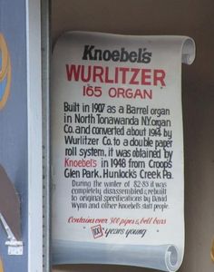 a sign that is on the side of a building with information about wurlitzer