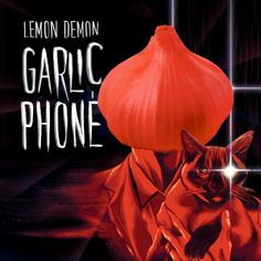 a cat sitting on top of a table next to an orange mushroom and the words garlic phone