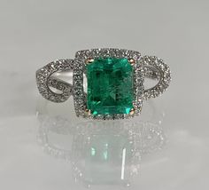 Square cut ring, emerald ring, emerald engagement ring, emerald ring for women, emerald diamond ring, 18k Emerald ring, 18K white gold ring A glowing modern emerald ring featuring a 1.27-carat emerald cut center stone accented by 0.42 carats of diamonds set in a solid 18k white gold twisted halo setting. *Ring size: US 6 3/4 *Ring weight: 4.30 Grams *Center stone dimensions: 7.5X6mm 14k White Gold Emerald Ring With Brilliant Cut, Green Diamond Platinum Ring Fine Jewelry, Fine Jewelry Green Diamond Ring In Platinum, Fine Jewelry Green Diamond Platinum Ring, Green Diamond Platinum Ring With Prong Setting, Green Diamond Cut Diamond Ring, Green Platinum Diamond Ring, Green Emerald Ring With Diamond Accents, Emerald Cut Green Diamond Ring With Diamond Accents