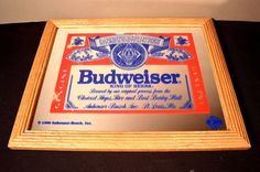 a framed budweiser label on display in a wooden frame