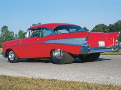 an old red car is parked on the street