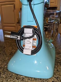 a blue blender with a black cord attached to it's side sitting on a counter