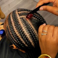 a person cutting another persons hair with scissors