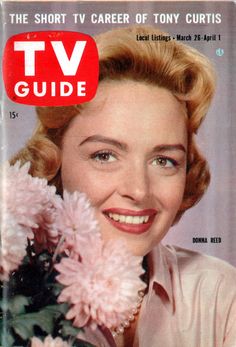 the cover of tv guide shows a smiling woman with flowers in her hair and wearing a white shirt