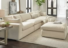 a living room filled with furniture and a large white couch in front of a doorway