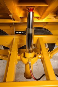 the back end of a yellow vehicle with two wheels and a hose connected to it