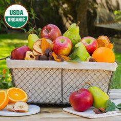 a basket filled with lots of fruit sitting on top of a wooden table