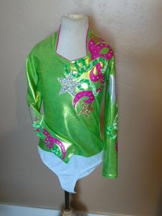 "Such a fun refreshing summer shirt just like our favorite drink! Sweetheart neckline is trimmed in metallic pink. Super Sparkly silver and gold stars and fun swirls adorn the shirt. About 100 high quality AB rhinestones. Comes with attached brief to stay tucked in. Zip back. Merchandise is shipped within 1 to 3 weeks. If needed by a certain date, message us right away, call us at 435.279.6246, or e-mail us at gloria [!at] rodeoqueenshirts.com to check availability. We try to keep 1 of every shi Pink Long Sleeve Festive Tops, Pink Long Sleeve Tops For Festive Occasions, Fitted Green Festive Top, Fitted Green Top For Festive Occasions, Green Stretch Sequined Tops, Festive Green Sequined Tops, Green Sequined Stretch Tops, Festive Green Sequin Tops, Fitted Long Sleeve Tops For Festive Occasions