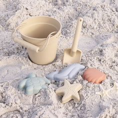 sand toys are laying in the sand with shovels and starfish