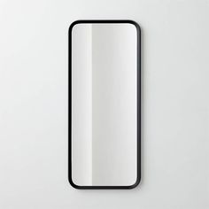 a mirror that is on the wall with a black frame and white backround