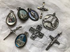 "These are old religious charms that can be put on a chain or charm bracelet. The largest circular one with Mary, Joseph and baby Jesus is marked sterling as is the square openwork cross. The charms encased in glass are silver plate and brass. The  other crosses are gold or silver plated.  All are included for the price. The circular charm is 1.25\" in diameter and all are at least 1\" long." Spiritual Silver Jewelry Souvenir, Vintage Metal Pendant Charms, Vintage Sterling Silver Crucifix Jewelry, Vintage Silver Cross Pendant Jewelry, Vintage Silver Cross Jewelry, Silver Pendant With Miraculous Medal, Silver Miraculous Medal Pendant, Nickel-free Cross Pendant Spiritual Jewelry, Silver Crucifix Necklace With Charms