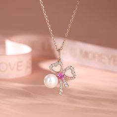 This clover shaped pendant captures the essence of romance with its beautiful design and intricate details. Nestled beneath the bow, a lustrous pearl symbolizes the precious moments shared. Grace your beloved with a gift as rare and captivating as your love. Let this necklace be a testament to the beauty that blossoms when hearts dance together.Carat Weight: 5.093 ctStone Size: 1,1.2,1.5,1.8,8,4.0 mmStone Type: Jeulia® StoneNumber of Stones: 42 Stone Color: Diamond White, FuchsiaStone Shape: Rou Elegant Heart Pendant Pearl Necklace Gift, Elegant Pearl Necklace With Heart Pendant, Elegant Pearl Necklace With Heart Pendant For Gift, Elegant Pink Necklace As A Gift, Feminine Bow Jewelry For Wedding, Elegant Pearl Heart Pendant Jewelry, Pearl Necklace With Flower Pendant As Gift, Pearl Pendant Jewelry For Wedding, Silver Pearl Necklace For Gift