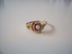 This vintage natural Pearl Black Hills Gold ring is set with 10 and 12 karat yellow, rose, and green gold. The ring is a size 6 and weighs approximately 1.7 grams. The pearl is 3 millimeters in size. This ring is in excellent condition and can be sized by a jeweler if needed. Questions? Please feel free to email me. Black Hills Gold Rings, Hippie Cowgirl, Leaves Ring, Flower And Leaves, Black Hills Gold, Leaf Ring, Black Hills, Natural Pearl, Pearl Flower