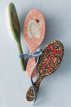 a pair of leopard print slippers next to a hair brush on a white surface