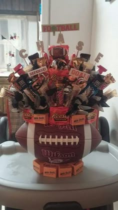 a football themed centerpiece with candy and candies in it on top of a table