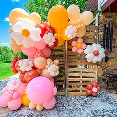 an outdoor area with balloons and flowers on the ground