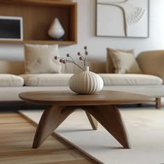 a living room with a couch, coffee table and vase on the floor in front of it