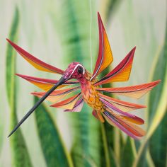 a colorful bird sitting on top of a flower