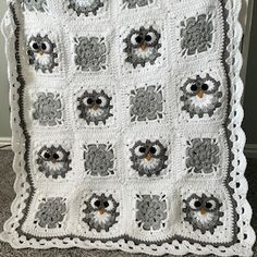 an owl themed crocheted blanket is displayed on the floor