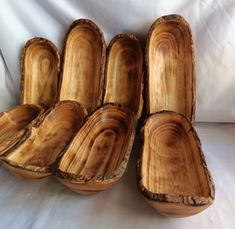 four wooden bowls sitting on top of a white sheet