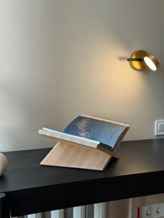 a book is sitting on top of a table next to a lamp and other items