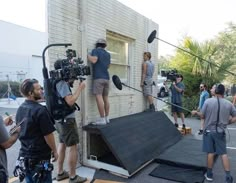 some people are filming something in front of a building